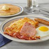 Breakfast sampler at iHOP includes ham, bacon, sausage, egg, hashbrowns, and pancakes.